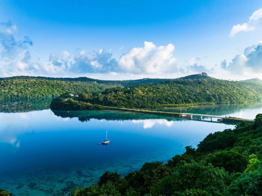 Yatch at sea facing a bridge connecting islands