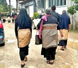 People walking wearing black and Tongan taovala 