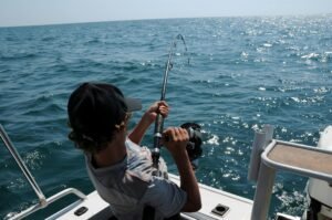 Man on a boat pulling his fishing rod