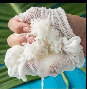 Coconut flesh being squeezed 